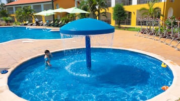Relax by the circular pool surrounded by lounge chairs and umbrellas.