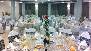 A banquet hall with round tables set for a formal event, featuring white tablecloths, glassware, and floral centerpieces. - Hotel rural Llano Piña (Loja)