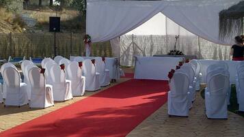 A red carpet aisle leading to a white tent with a table and chairs.