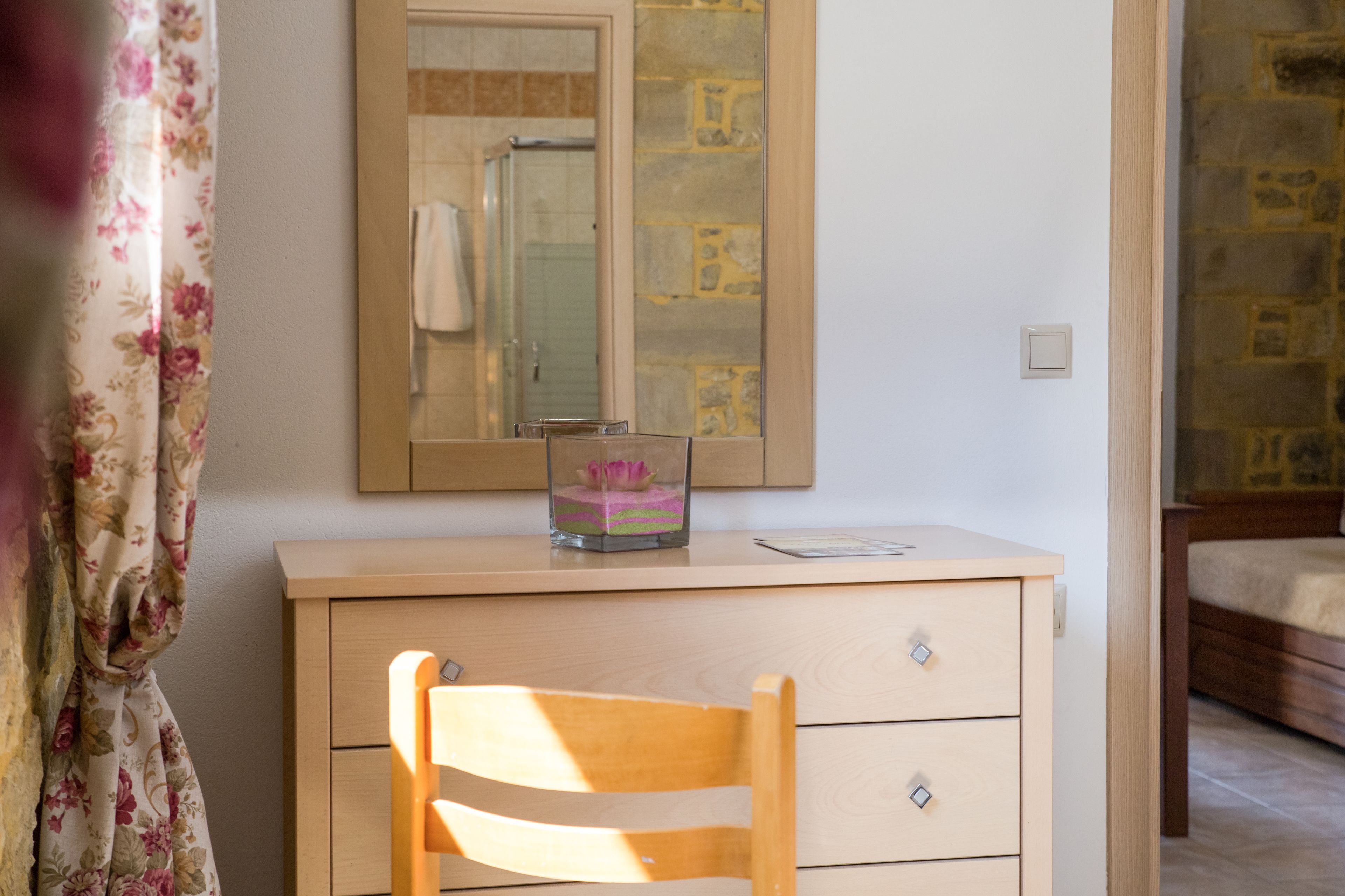 Un dormitorio con un aparador de madera, un espejo y una cama.