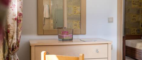 Un dormitorio con un aparador de madera, un espejo y una cama.