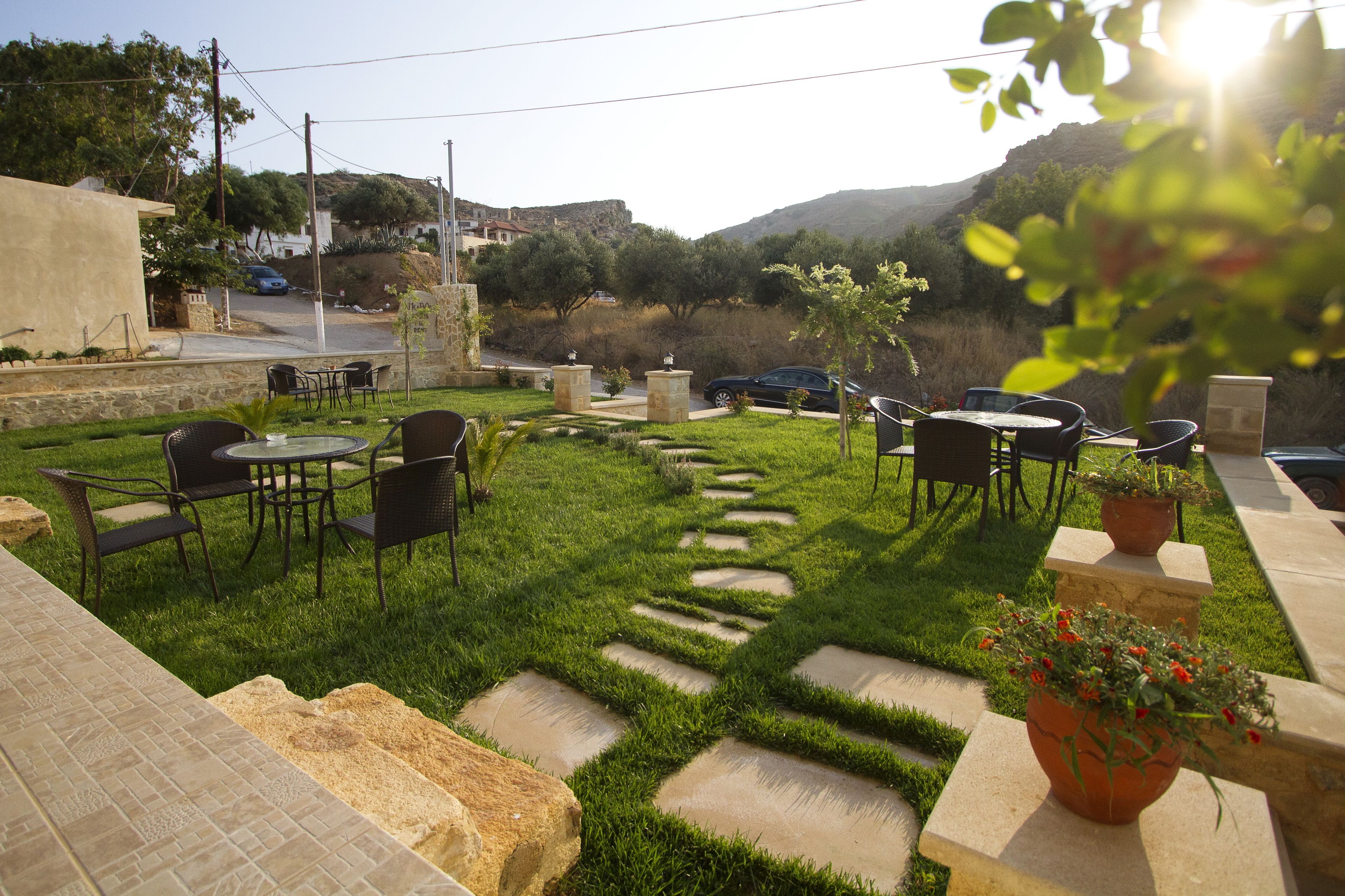 Un patio con escalones de piedra, mobiliario exterior y vistas a una colina.