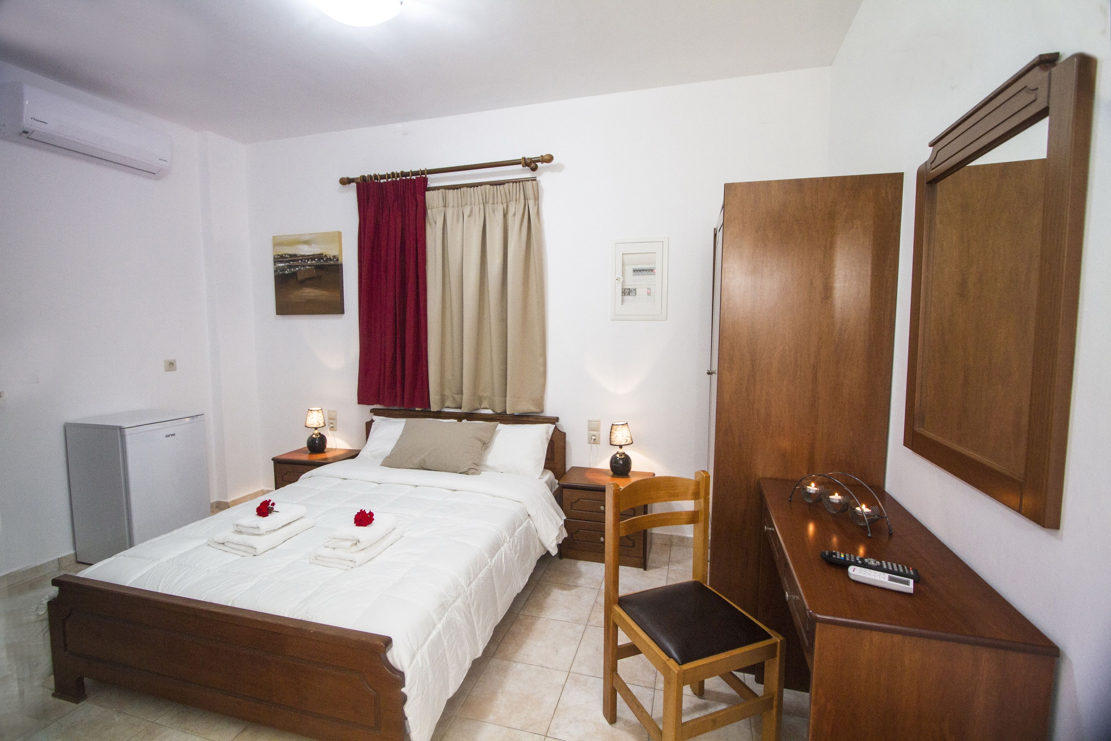 Une chambre bien rangée, avec un lit, des tables de chevet, une chaise, un bureau et une armoire.
