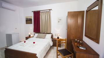 Une chambre bien rangée, avec un lit, des tables de chevet, une chaise, un bureau et une armoire.