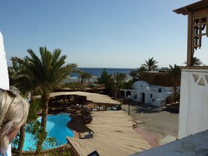 A resort with a pool, palm trees, and a view of the sea. - Inmo Divers home (Dahab)