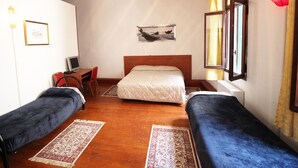 A room with two single beds, a desk with a chair, a computer, and a painting on the wall. - Residenza Della Spada (Venice)