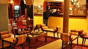 A lobby with a bar area, seating with striped cushions, and a patterned rug. - Residenza Della Spada (Venice)