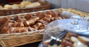 Verschillende gebakken producten, waaronder croissants en brood, gepresenteerd in rieten manden.