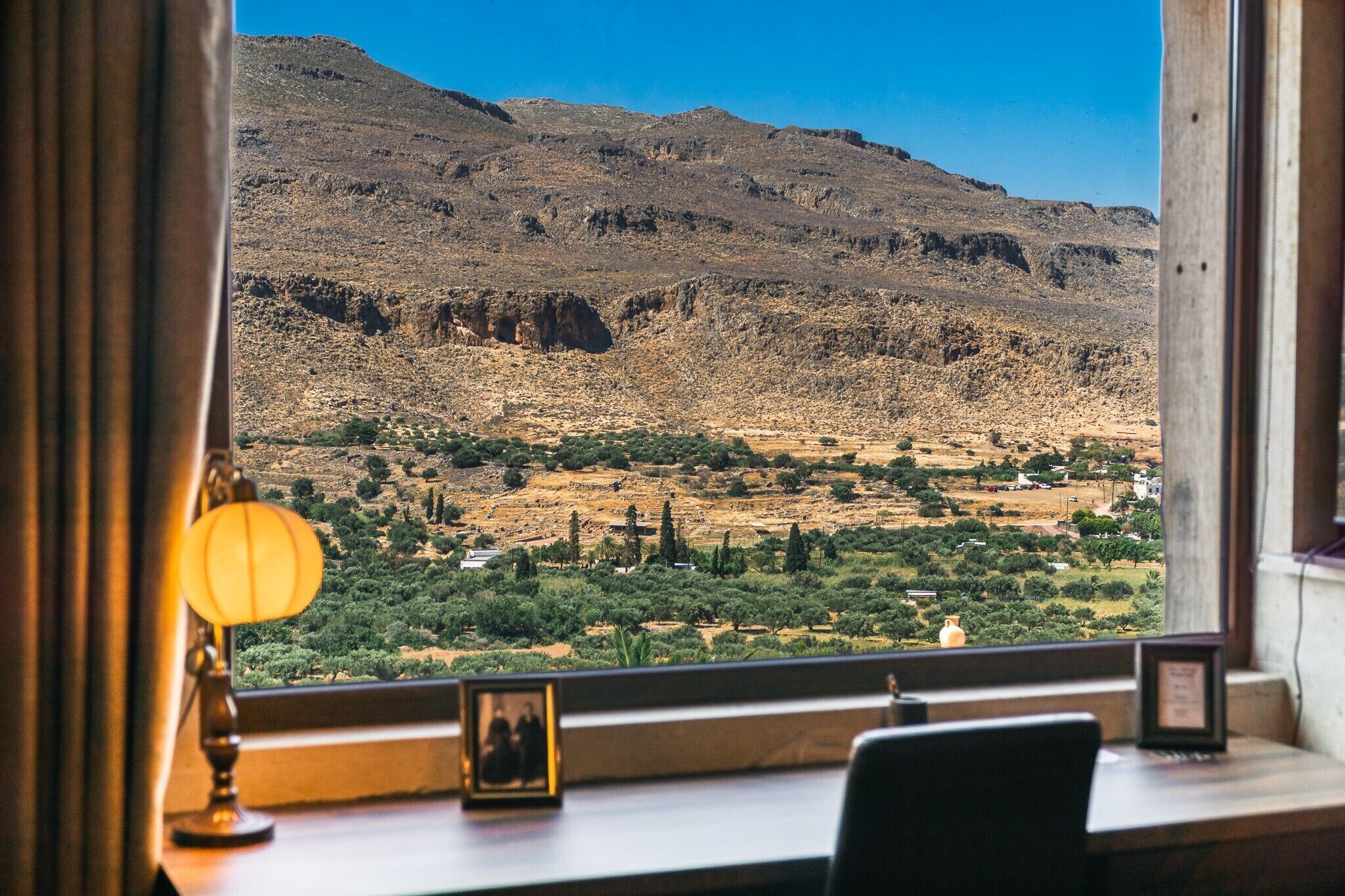 Une pièce avec vue sur un paysage montagneux, visible par une fenêtre.