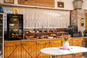 Una cocina con un refrigerador, una cafetera y diversos alimentos sobre la encimera.