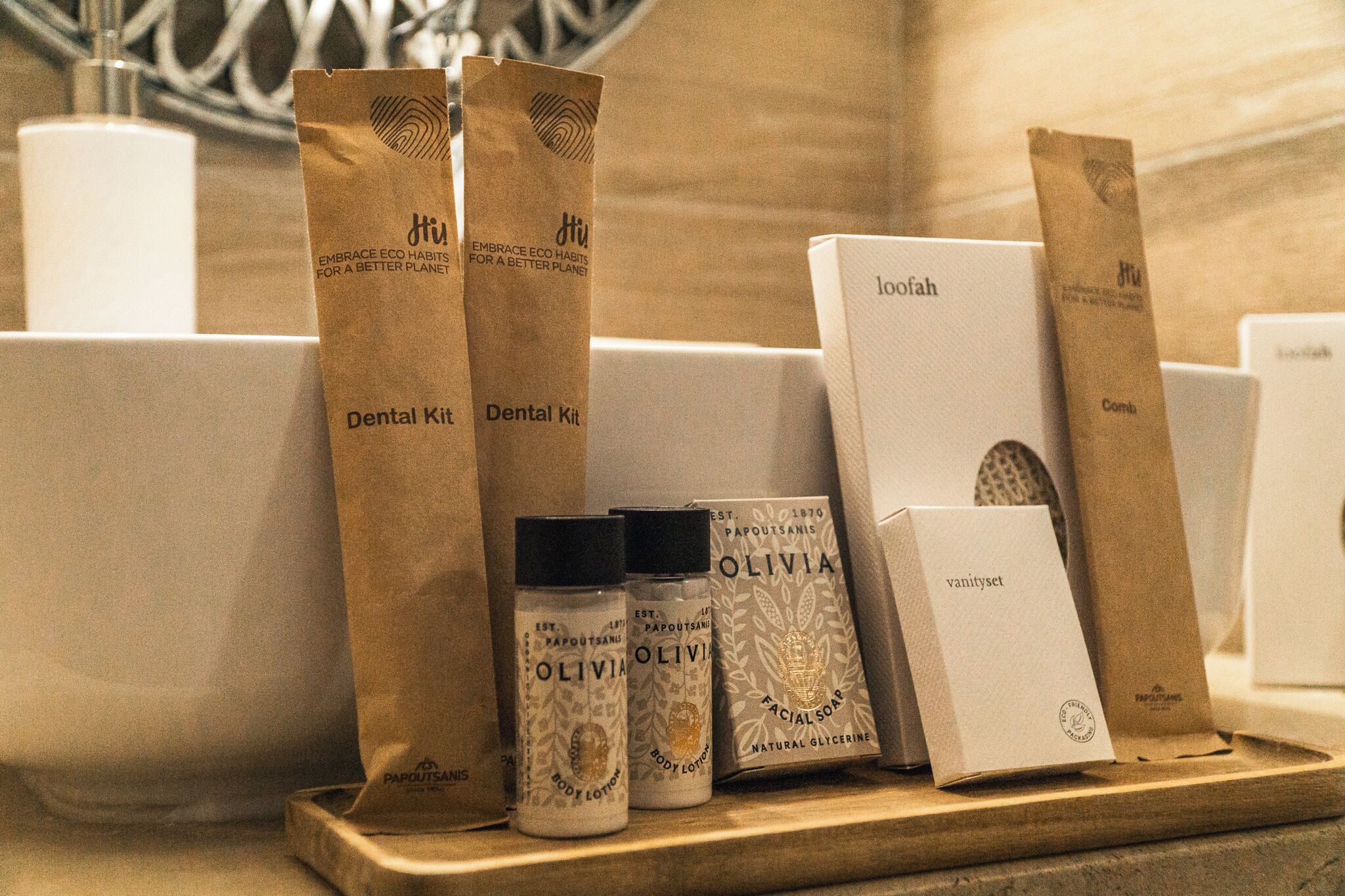 Una estant amb diversos productes de cura personal, incloent kits dentals, loció corporal, sabó facial i un pentini.