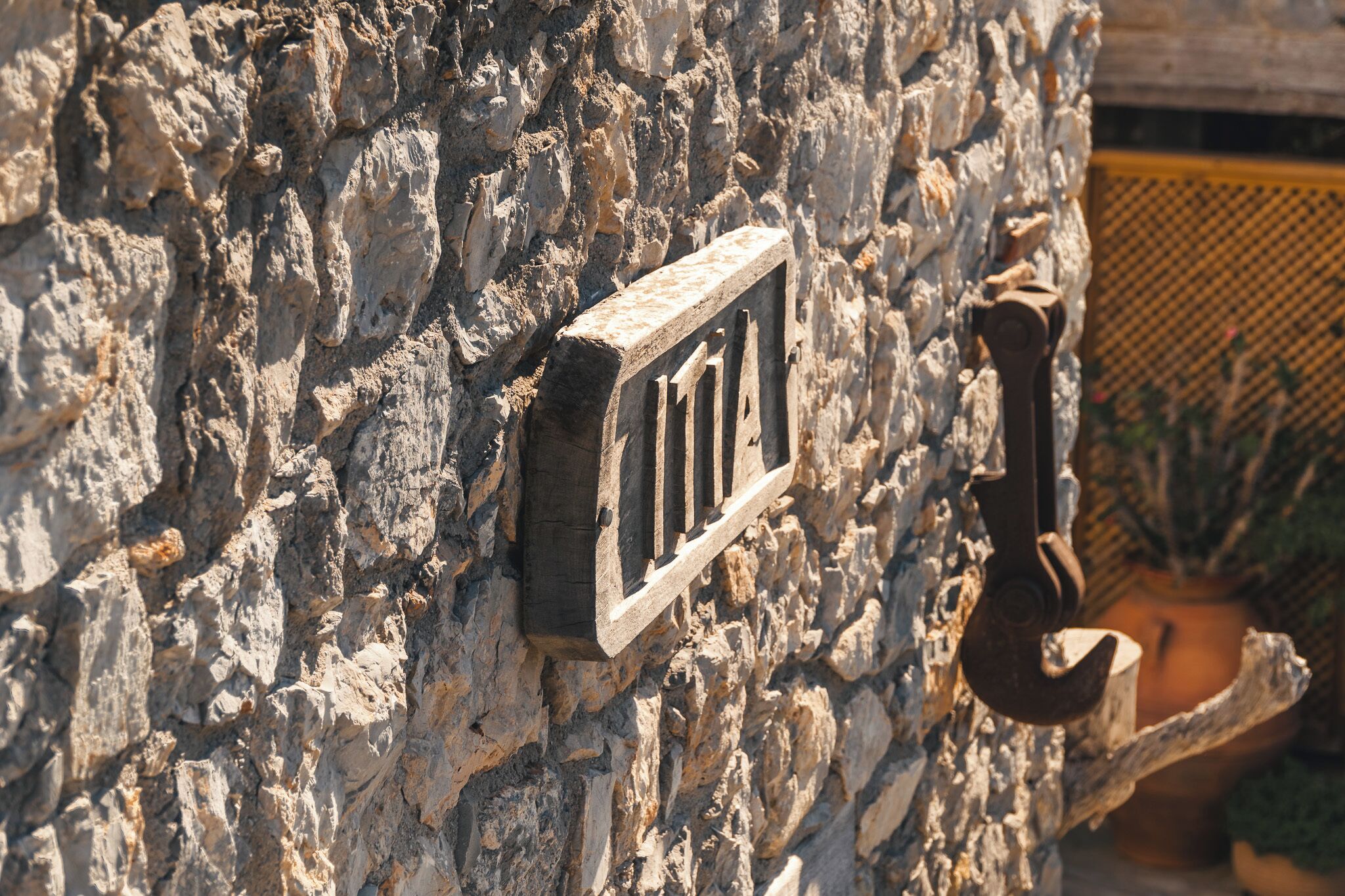 Pared de piedra con un tirador de metal y una placa metálica rectangular.