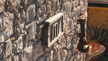 Pared de piedra con un tirador de metal y una placa metálica rectangular.