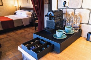 A kitchenette with a coffee maker, cups, and water bottles. - Terra Minoika Resort (Sitia)