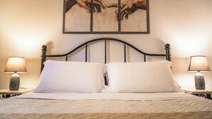 Una cama con dos almohadas, cabecero y dos lámparas de noche.