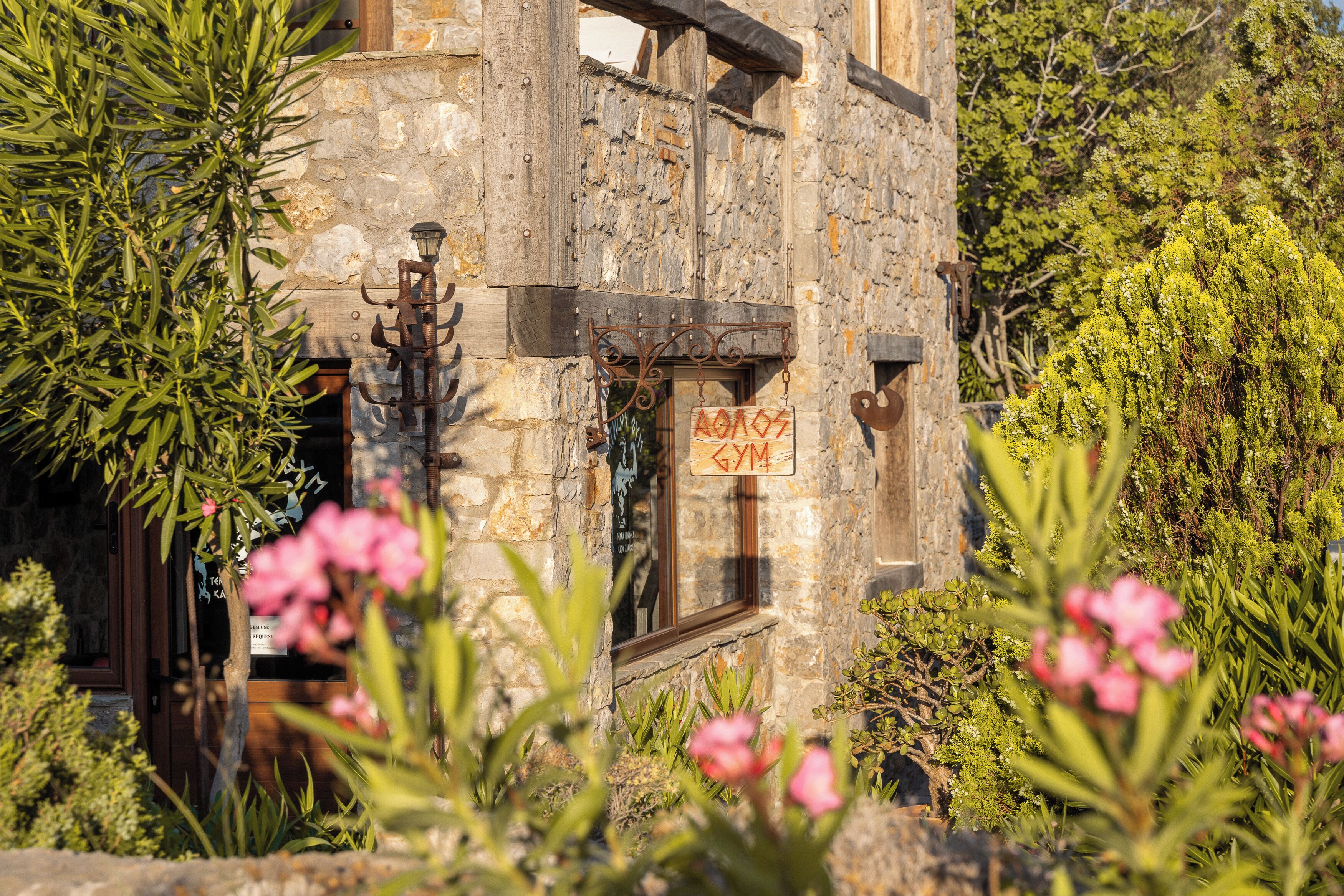 A rustic stone building with a sign indicating a gym.