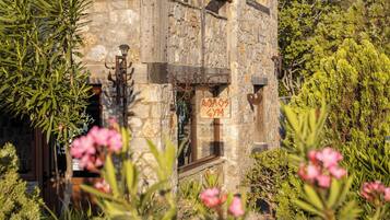 A rustic stone building with a sign indicating a gym.