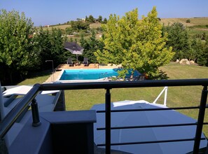 A swimming pool with a view of a hillside, surrounded by trees and a grassy area. - Sunny Sani Luxury Villas (Kassandra)