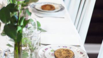 A dining table set with plates, glasses, and a cake.