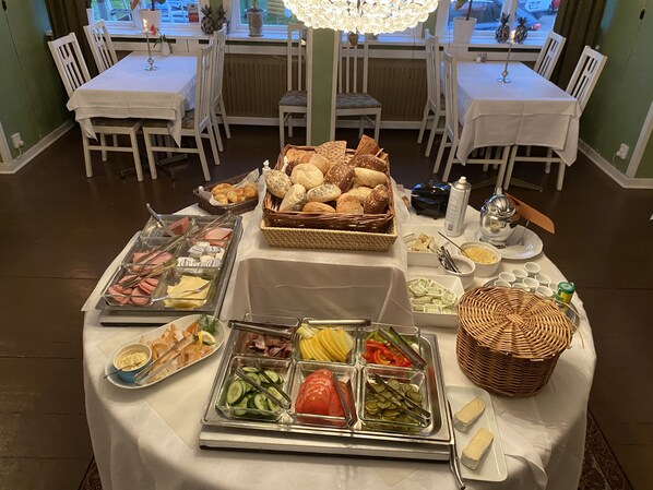 Montaje tipo bufé con diversos alimentos y vista al comedor.