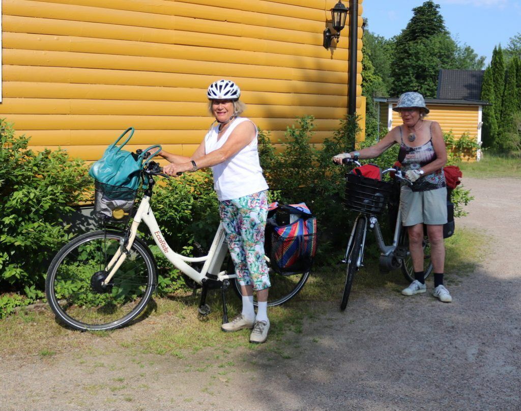 Two bicycles parked in front of a yellow wooden building.