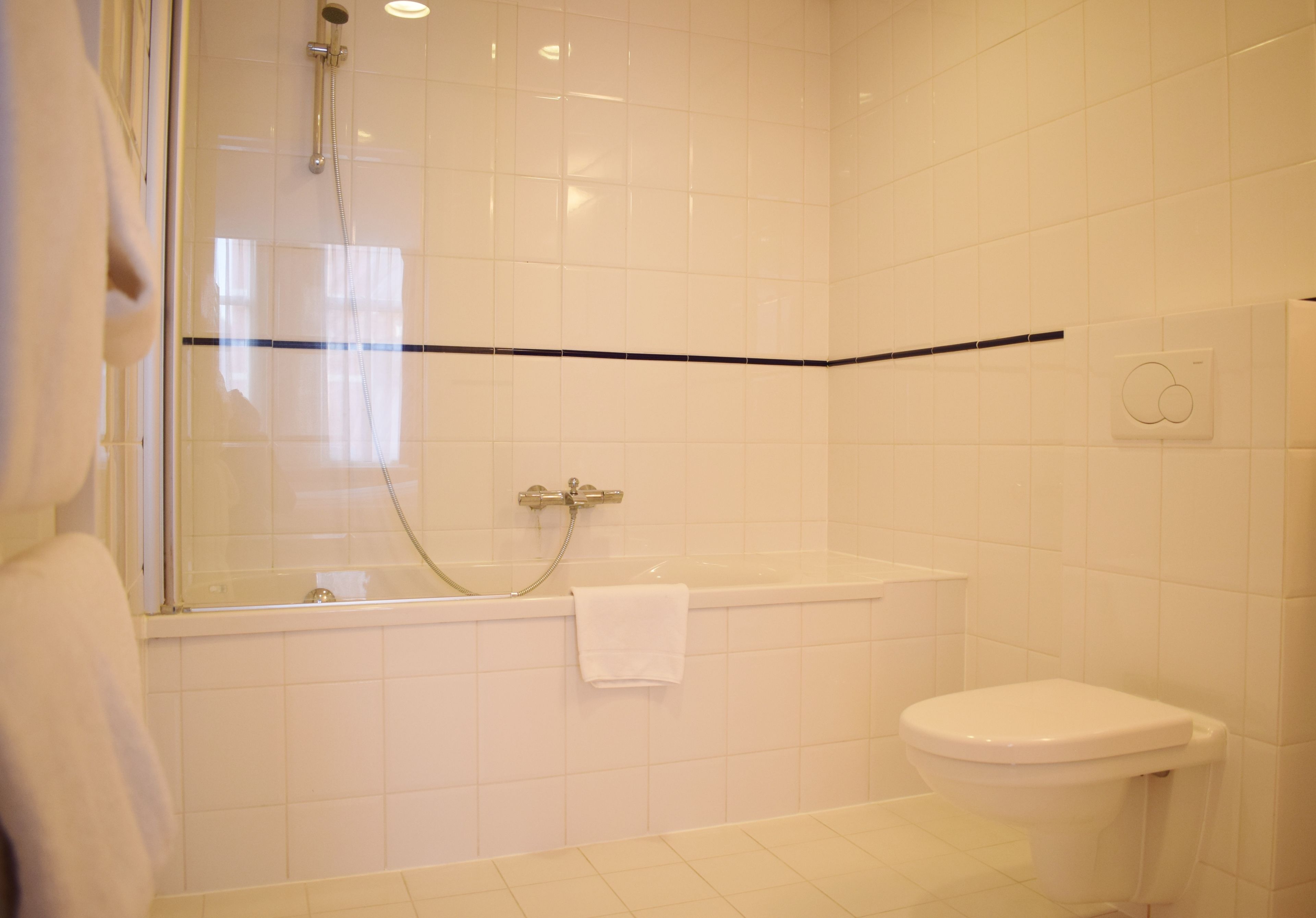A bathroom with a glass-enclosed shower, a bathtub, and a toilet.