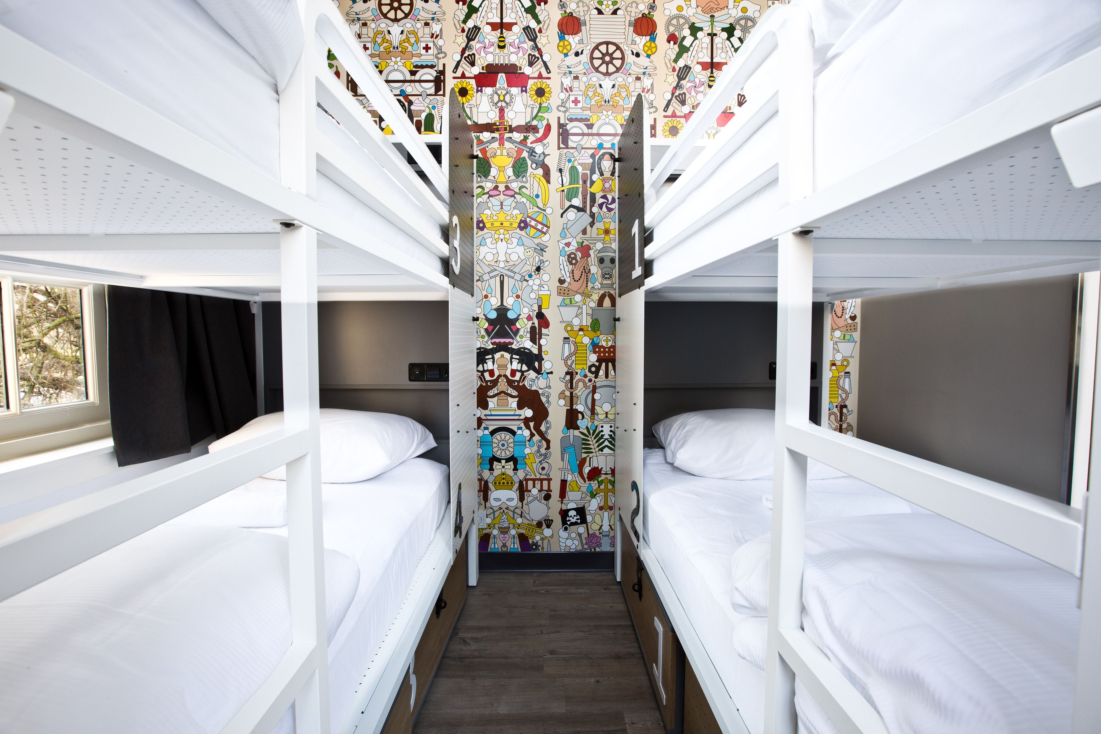 A bunk bed room with a colorful mural on the wall.