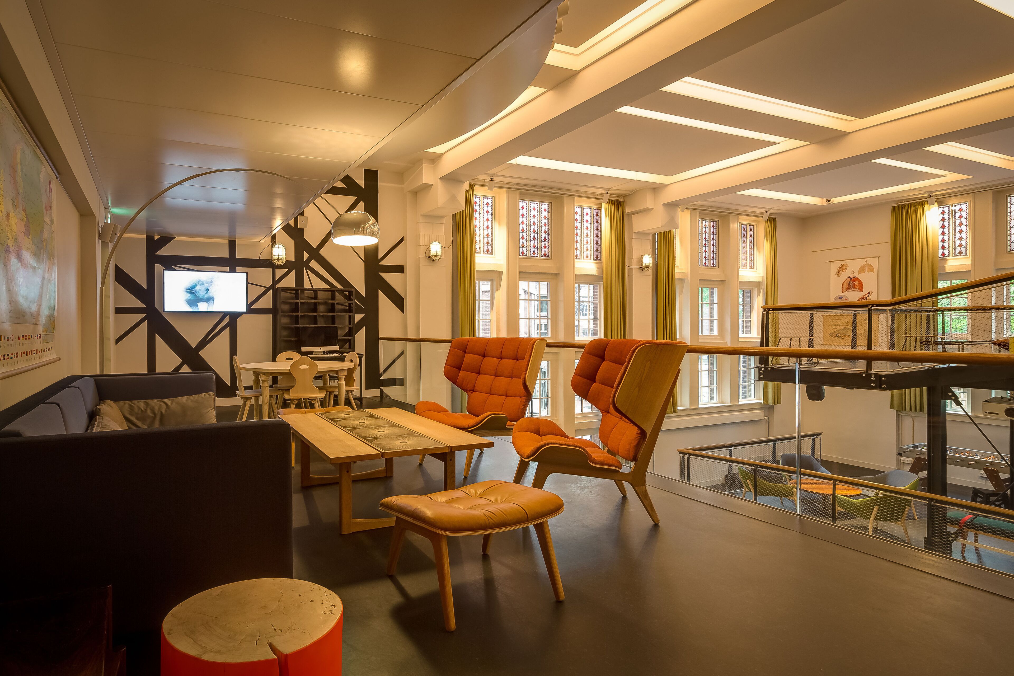A modern interior with a staircase, seating area, and large windows.