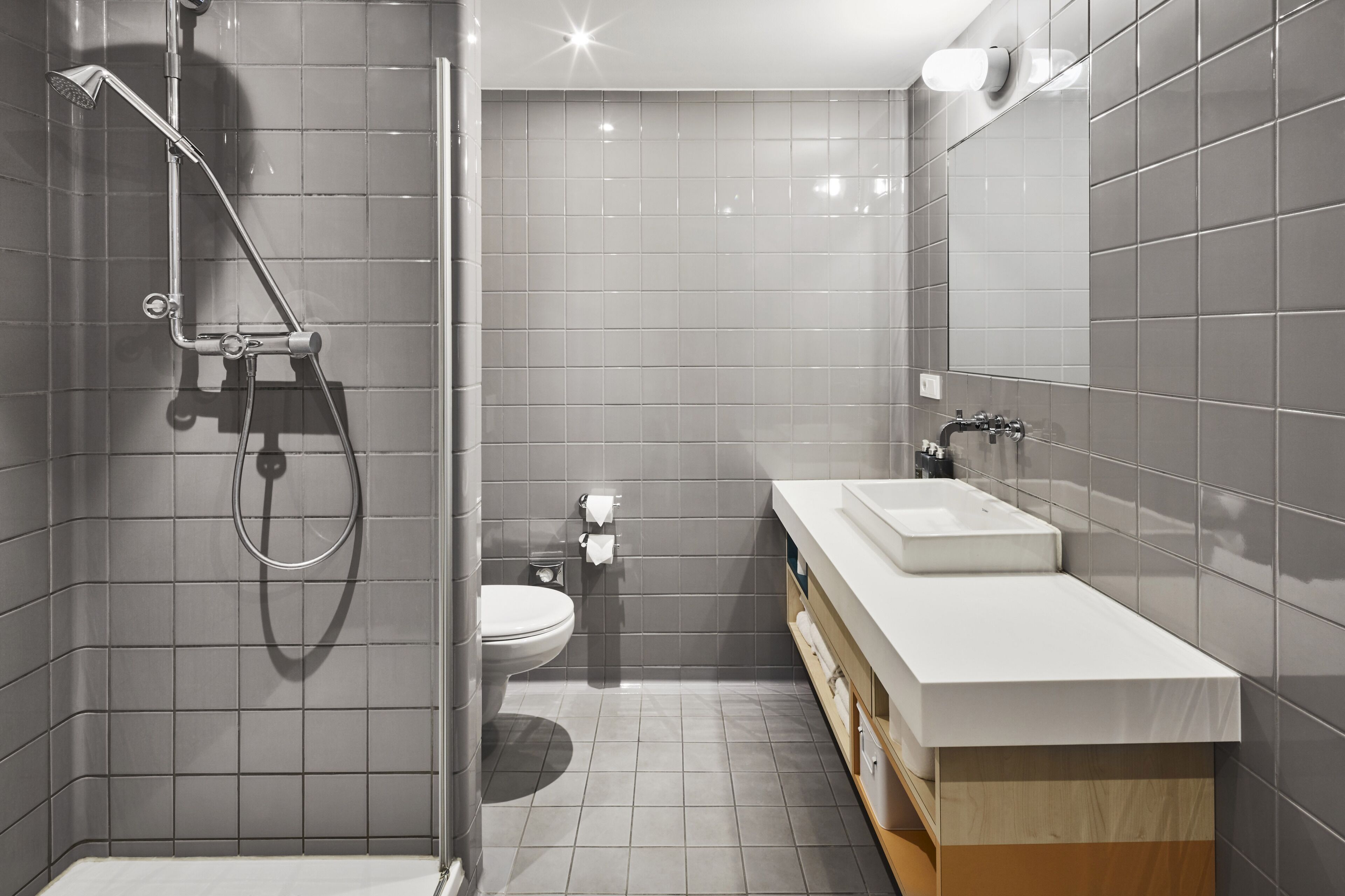 Un baño moderno con ducha, inodoro y tocador.