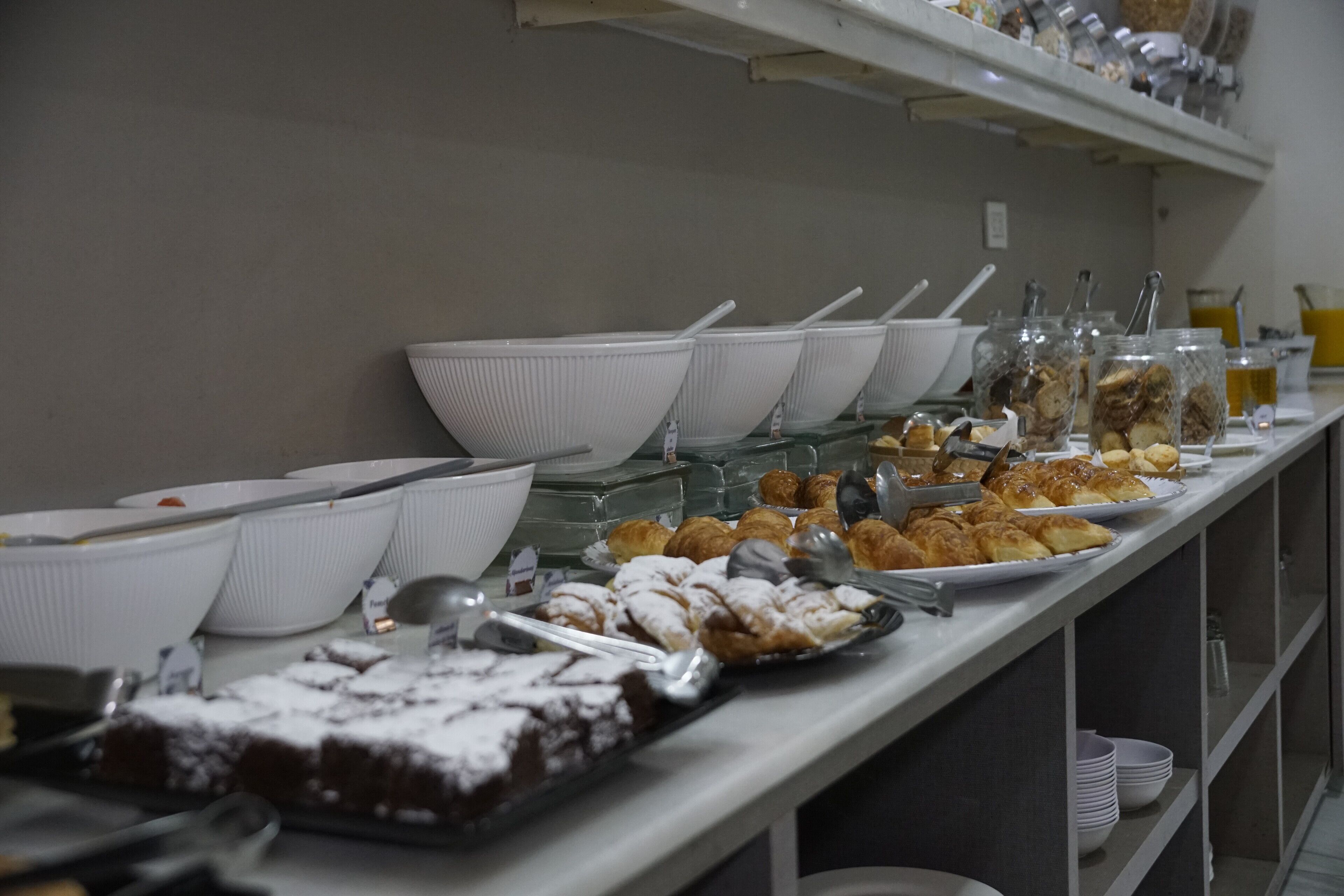 Um buffet com diversos alimentos e utensílios de servir.