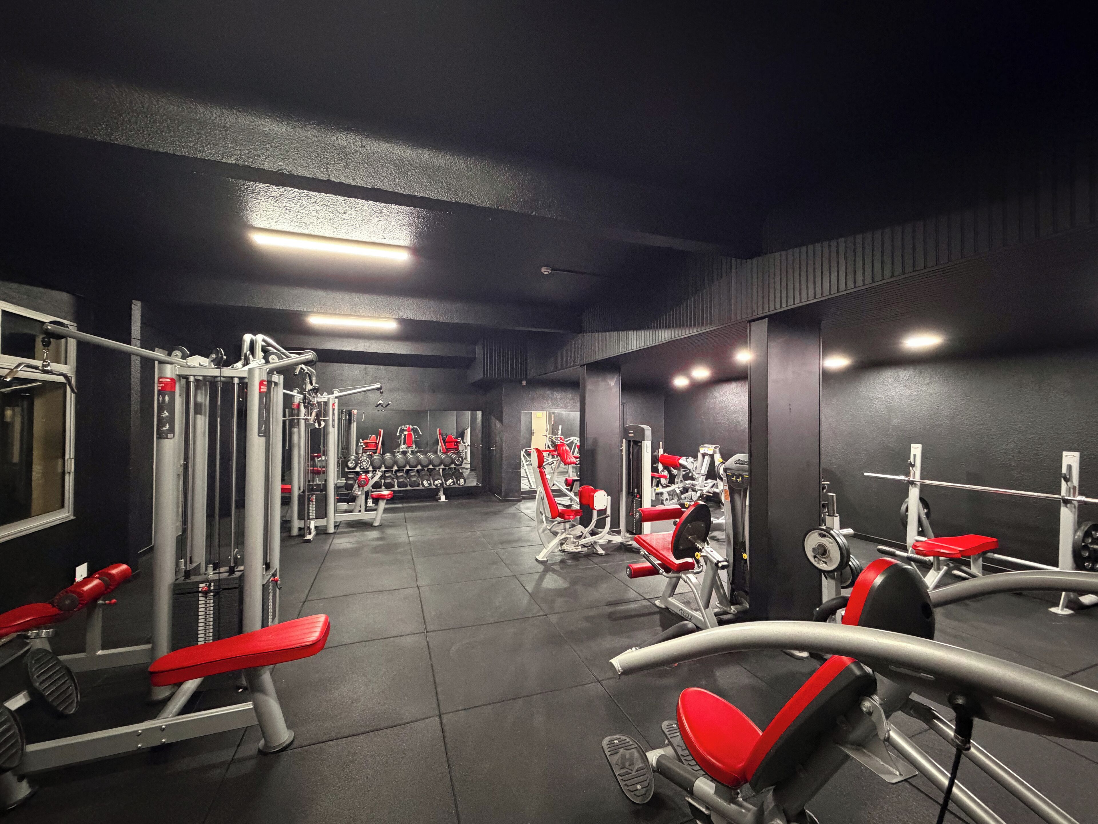 A gym with various exercise equipment, including weight machines and benches.