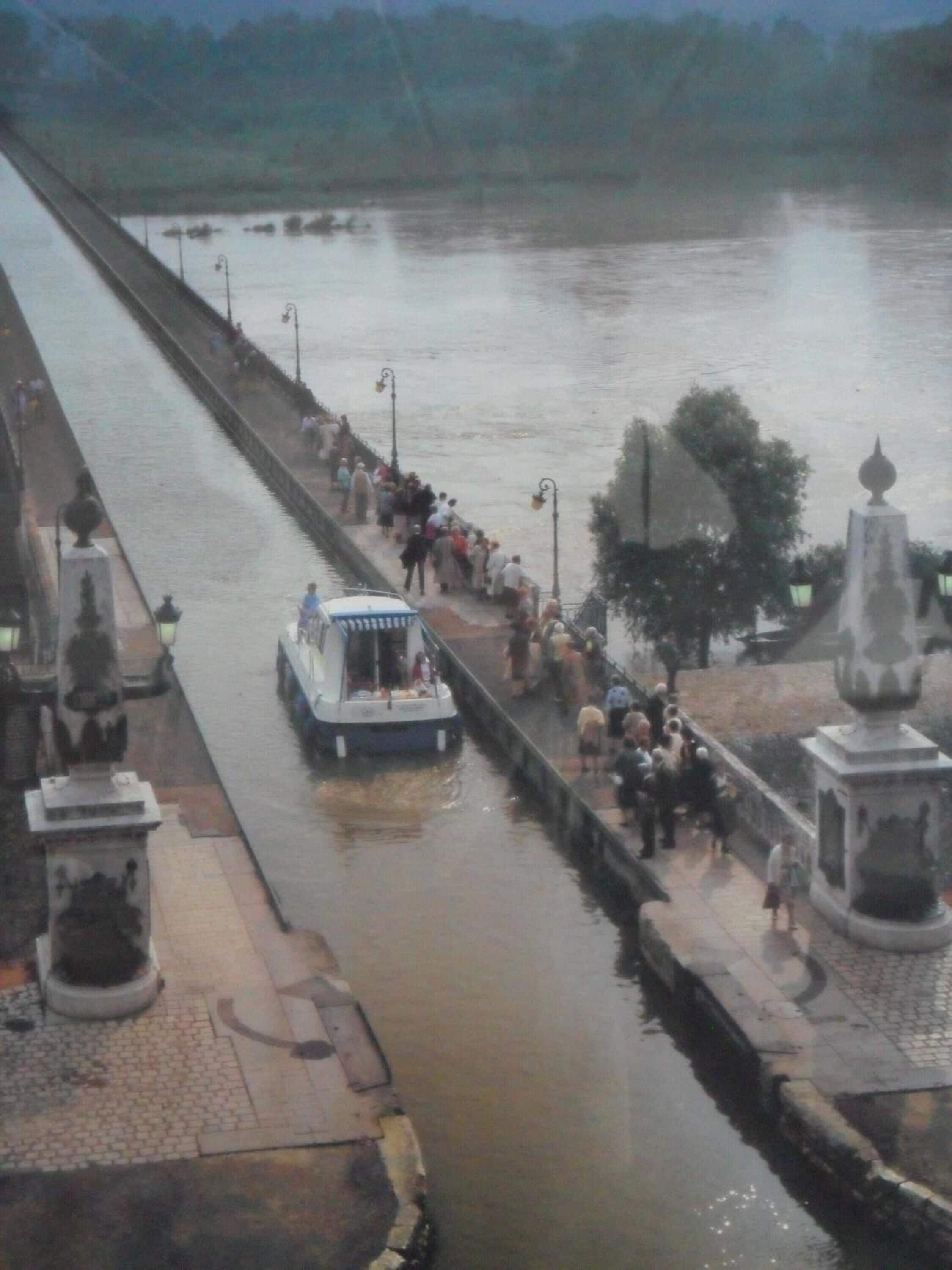 Un río con una barca y gente en la orilla.