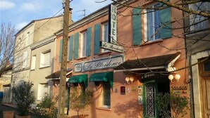 A hotel named "La Residence" with a signboard, green awnings, and a traditional facade.
