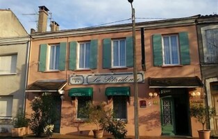 Un edificio de dos pisos con un cartel que dice "HOTEL La Résidence".