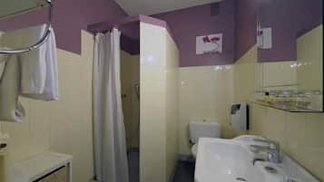 Ein Badezimmer mit Dusche, Toilette, Waschbecken und Spiegel.