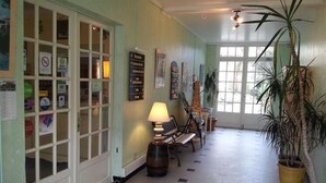 A hallway with a lamp, a bench, and a potted plant.
