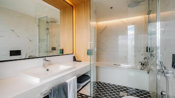 Un bagno moderno con cabina doccia in vetro, lavandino bianco e pavimento piastrellato in bianco e nero.