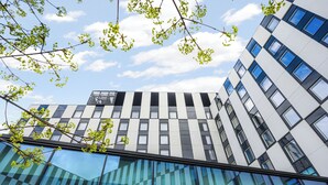 Un edificio moderno con fachada de vidrio y un letrero que dice 'CLARION HOTEL'.