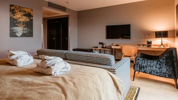 Una habitación de hotel con cama, escritorio, silla y televisión.