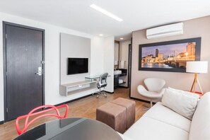 Relax in a stylish space with a flat-screen TV, comfortable sofa, and seating options.