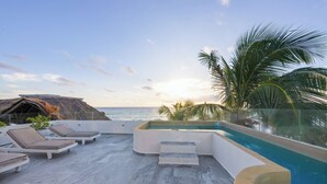 A rooftop pool area with lounge chairs and a hot tub, overlooking the ocean. - Playa Canek Beachfront Eco Hotel (Tulum)