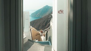Una ventana con vistas a un paisaje montañoso y un edificio con el logotipo 'CR'.