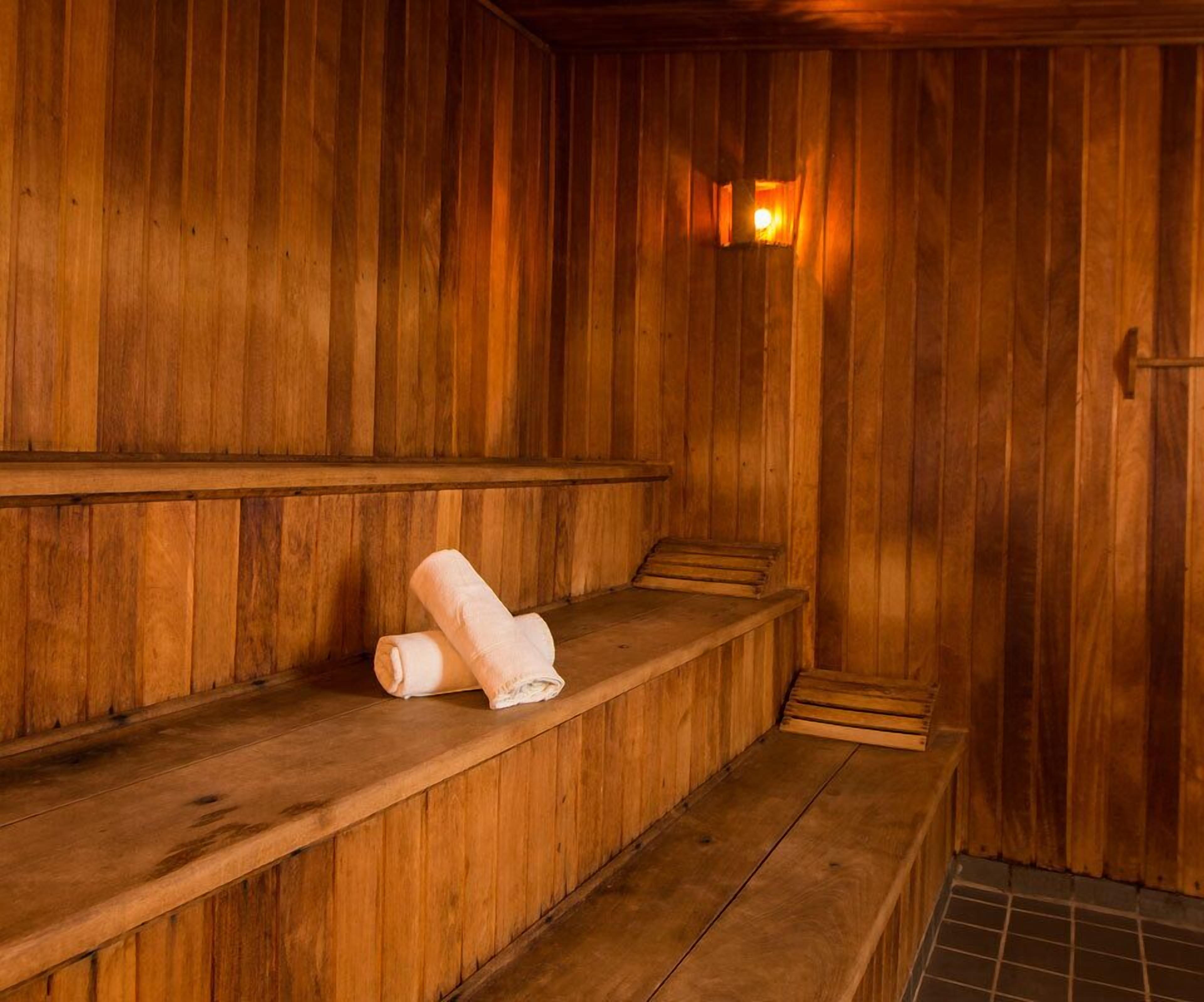 Una sauna de madera con bancos y una toalla sobre uno de ellos.