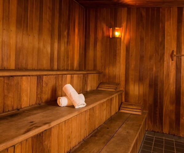 A wooden sauna with benches and a towel on one of the benches.