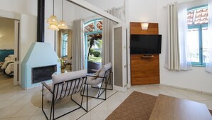 Una sala de estar moderna con chimenea, televisor y zona de comedor.