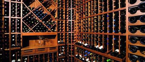 A wine cellar with wooden racks filled with wine bottles.