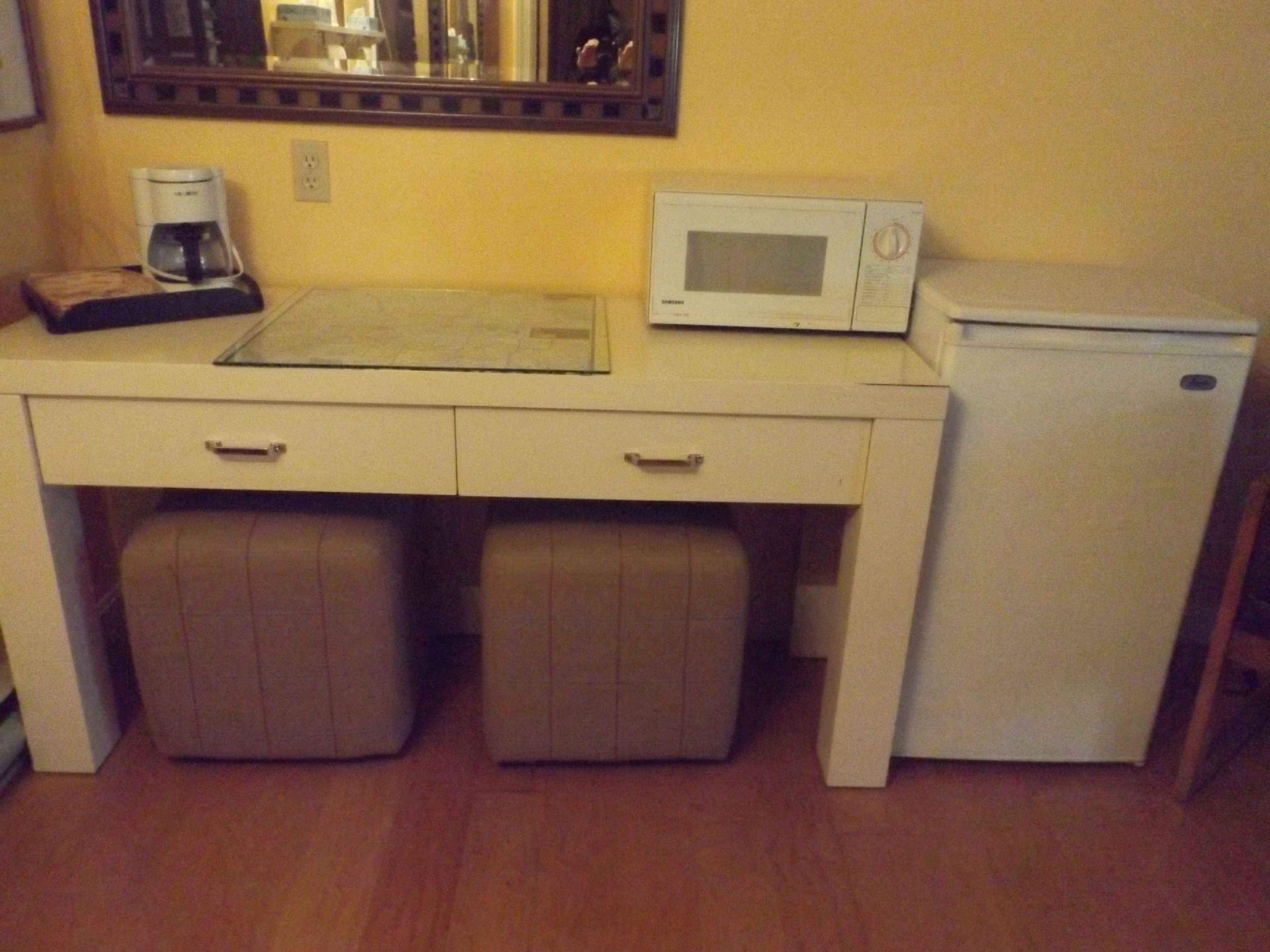 A compact kitchenette with a microwave, coffee maker, and mini-fridge.