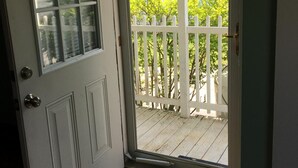 Una porta con un vetro che mostra un recinto di legno bianco.