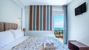 Een hotelkamer met een bed, een aan de muur bevestigde televisie en een balkon met uitzicht.