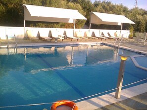 Une piscine avec des chaises longues et des parasols.